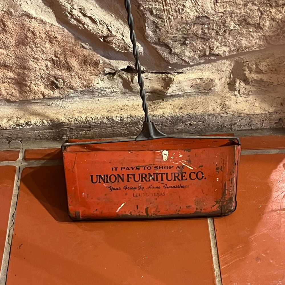 A metal vintage advertising dustpan with long handle from the Union Furniture Co